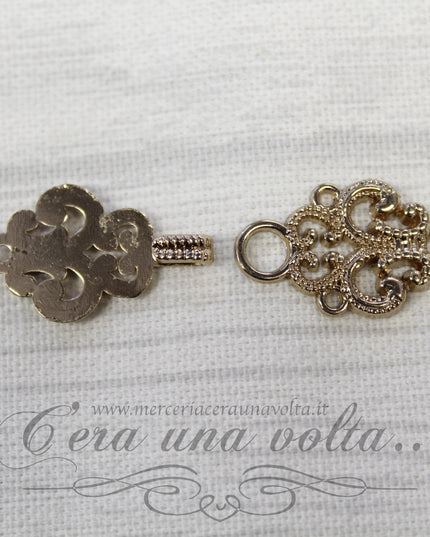 Agganciature con intrecci e intarsi oro