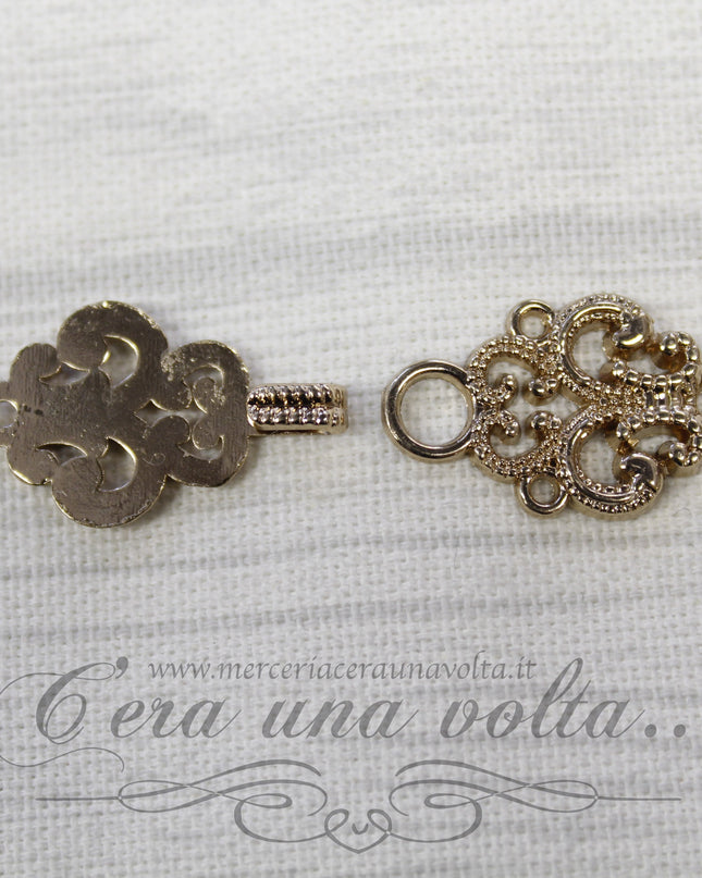 Agganciature con intrecci e intarsi oro