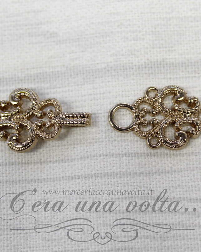 Agganciature con intrecci e intarsi oro