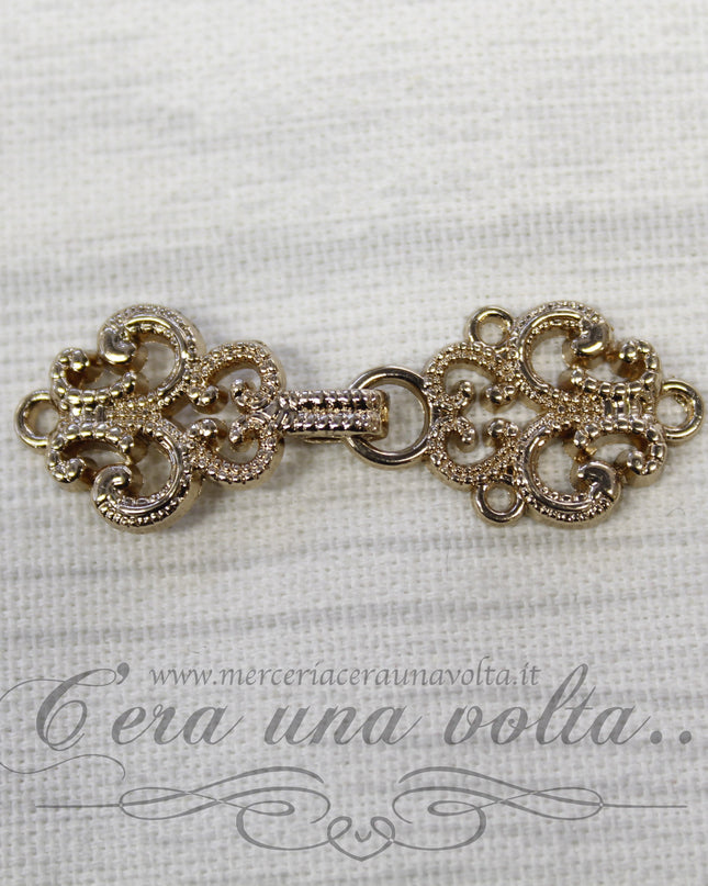 Agganciature con intrecci e intarsi oro